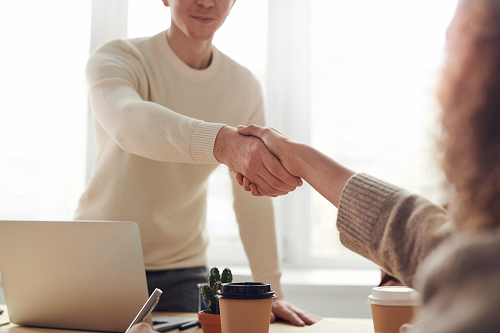 A business meeting between two people shaking hands.